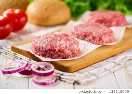 Raw burger beef patties on a white table, selective focus. Raw burger beef patties on a white table, selective focus. 135118909