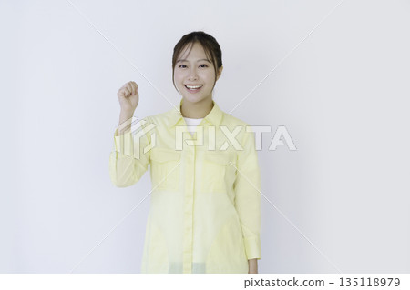 Portrait of a young Japanese man looking at the camera and making a fist pump on a white background Portrait of a young Japanese man looking at the camera and making a fist pump on a white background 135118979