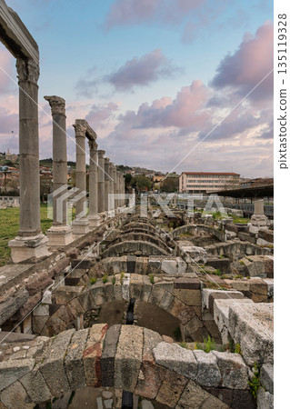Ancient columns and arched structures of Izmir Agora Open Air Museum, Izmir, Turkey, with colorful clouds. 135119328