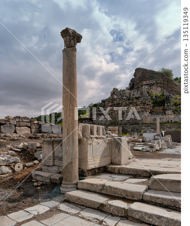Ancient Ephesus ruins with a Corinthian column and historical stone architecture under a cloudy sky, Selcuk, Turkey. Ancient Ephesus ruins with a Corinthian column and historical stone architecture under a cloudy sky, Selcuk, Turkey. 135119349