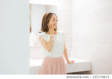 Young woman looking at a mirror 135119623