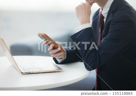 年輕的商人在智能手機上交談 135119865