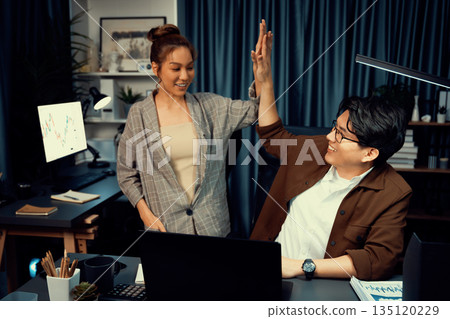 Smiling business trader with partner in casual suit taking high five. Infobahn. 135120229