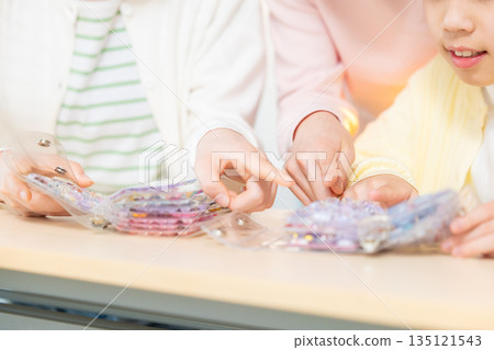 小學生放學後用貼紙簿交換貼紙，玩得不亦樂乎。 135121543