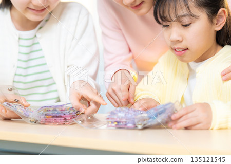 小學生放學後用貼紙簿交換貼紙，玩得不亦樂乎。 135121545