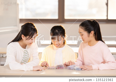 小學生放學後用貼紙簿交換貼紙，玩得不亦樂乎。 135121561