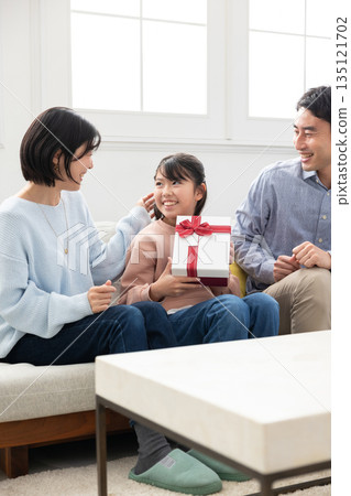 小學生女孩很高興收到父母送的聖誕禮物 小學生女孩很高興收到父母送的聖誕禮物 135121702
