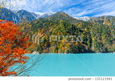 Taira, Omachi City, Nagano Prefecture - The vivid milky blue of the Takase Dam regulating lake, with its autumn leaves and snow-capped mountains. Taira, Omachi City, Nagano Prefecture - The vivid milky blue of the Takase Dam regulating lake, with its autumn leaves and snow-capped mountains. 135121991