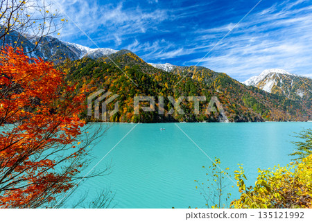 Taira, Omachi City, Nagano Prefecture - The vivid milky blue of the Takase Dam regulating lake, with its autumn leaves and snow-capped mountains. Taira, Omachi City, Nagano Prefecture - The vivid milky blue of the Takase Dam regulating lake, with its autumn leaves and snow-capped mountains. 135121992