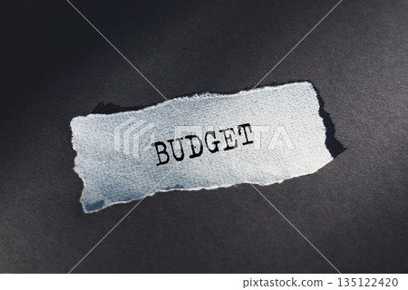 Word BUDGET on white wrinkled sheet of paper on black background 135122420
