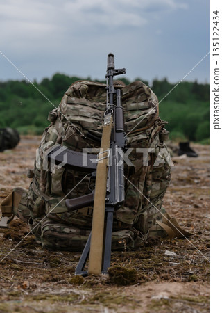 Army backpack with AK rifle isolated on nature background Army backpack with AK rifle isolated on nature background 135122434