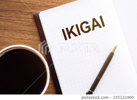 A notebook with IKIGAI written on it lies next to a coffee cup and pen, inviting reflection and planning. 135122460