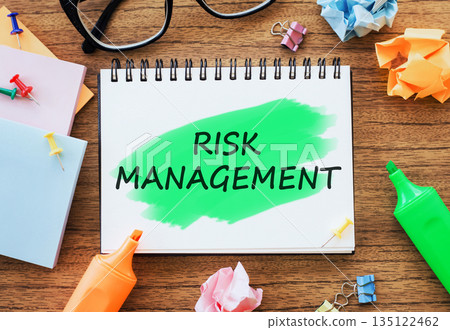 Office wooden table with a notebook RISK MANAGEMENT with markers, paper clips, crumpled paper. Business concept top view. 135122462