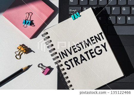 Notebook with tools and notes about INVESTMENT STRATEGY lies on laptop. Business concept Notebook with tools and notes about INVESTMENT STRATEGY lies on laptop. Business concept 135122466