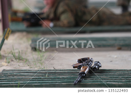 Close-up of a Kalashnikov assault rifle against the background of firing soldiers 135122493