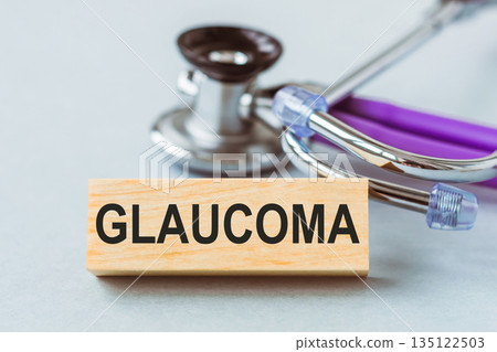 Wooden block with text GLAUCOMA lying on light blue background next to a stethoscope Wooden block with text GLAUCOMA lying on light blue background next to a stethoscope 135122503