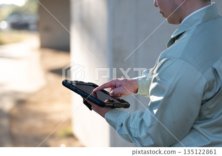 A construction manager operating a tablet device A construction manager operating a tablet device 135122861