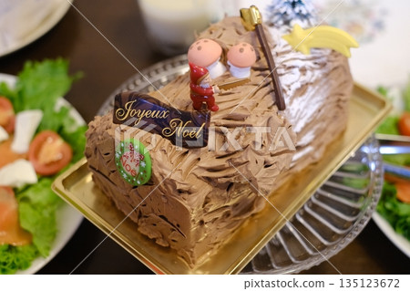 Chocolate roll cake and homemade food on the Christmas table 135123672