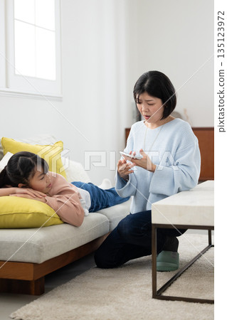 A mother scolding her elementary school daughter with a smartphone in her hand 135123972