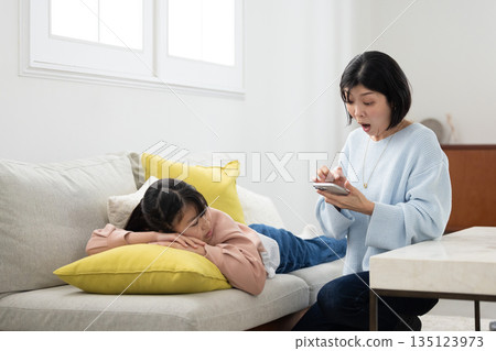A mother scolding her elementary school daughter with a smartphone in her hand 135123973