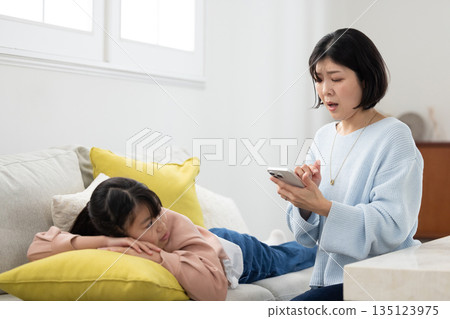 A mother scolding her elementary school daughter with a smartphone in her hand A mother scolding her elementary school daughter with a smartphone in her hand 135123975