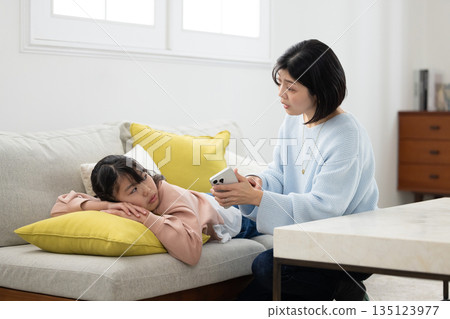A mother scolding her elementary school daughter with a smartphone in her hand 135123977