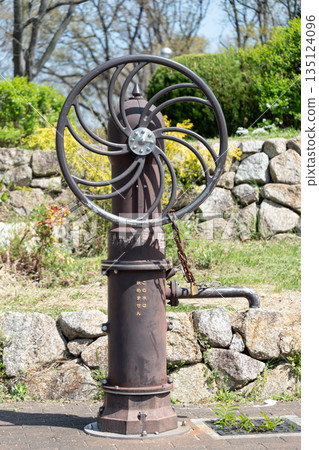 公園裡安裝了一個用於災害防範的手動水泵,泵體呈現銹鐵質感(緊急井,不可飲用,使用雨水)。 公園裡安裝了一個用於災害防範的手動水泵,泵體呈現銹鐵質感(緊急井,不可飲用,使用雨水)。 135124096