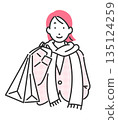 A woman wearing winter clothes carrying a shopping bag 135124259