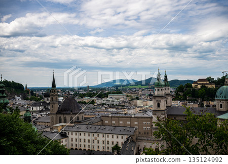 Panoramic view of Salzburg old town with historic churches and city skyline under cloudy sky Panoramic view of Salzburg old town with historic churches and city skyline under cloudy sky 135124992