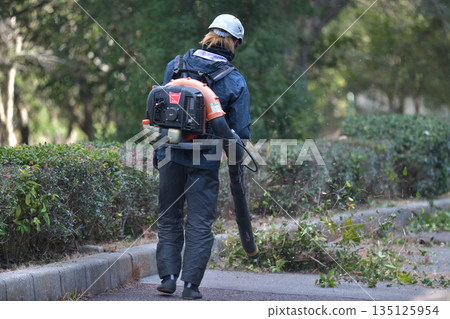 公園維護：用吹風機清除修剪下來的樹枝和落葉。 135125954