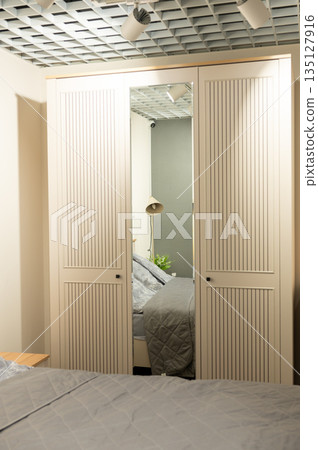 Modern minimalist bedroom design with white wardrobe and gray bedding Modern minimalist bedroom design with white wardrobe and gray bedding 135127916