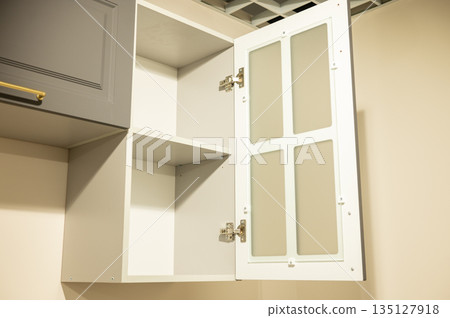 Open kitchen cabinet with glass-paneled door and shelves Open kitchen cabinet with glass-paneled door and shelves 135127918