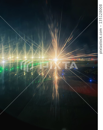 Bright runway lights, dramatic starburst effects on an airport runway at night, seen from an airplane window. Aviation, night travel, airport runway lights, aircraft movement Bright runway lights, dramatic starburst effects on an airport runway at night, seen from an airplane window. Aviation, night travel, airport runway lights, aircraft movement 135128008