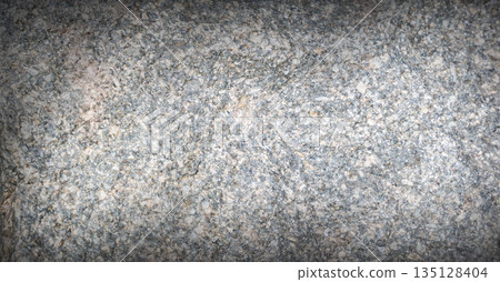 Natural gray granite stone texture with detailed mineral grains and subtle speckled pattern. Rough stone surface with organic variations 135128404
