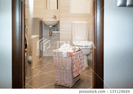 Wicker basket with dirty laundry in bathroom Wicker basket with dirty laundry in bathroom 135128689