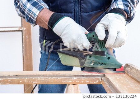 Carpenter at work, restoring an old wooden window. Carpentry. 135130224