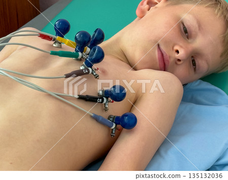 Child undergoing electrocardiogram examination in medical clinic 135132036