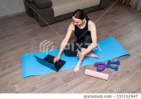 Home fitness workout with yoga mat, dumbbells, foam roller and resistance band Home fitness workout with yoga mat, dumbbells, foam roller and resistance band 135132947