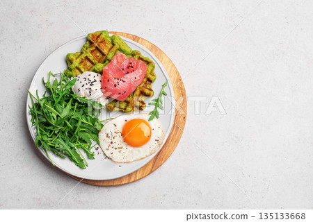 Healthy breakfast with green spinach waffles, salmon, cream cheese, fried egg and salad Healthy breakfast with green spinach waffles, salmon, cream cheese, fried egg and salad 135133668