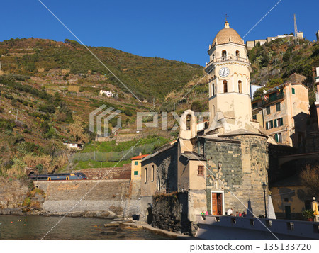 View of Vernazza, a town in Cinque Terre, from the mountain. Nature and sea, traditional buildings of Liguria, Italy. Architecture protected by UNESCO. Church of Santa Margherita. 135133720