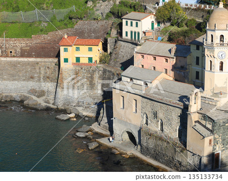 View of Vernazza, a town in Cinque Terre, from the mountain. Nature and sea, traditional buildings of Liguria, Italy. Architecture protected by UNESCO. Church of Santa Margherita. 135133734