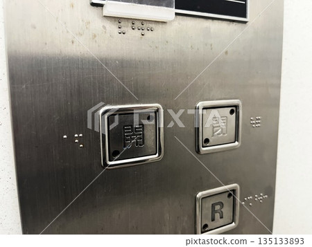 Open/close button of an old apartment building elevator Open/close button of an old apartment building elevator 135133893