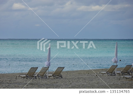 Okinawa beach lined with parasols and chairs Okinawa beach lined with parasols and chairs 135134765