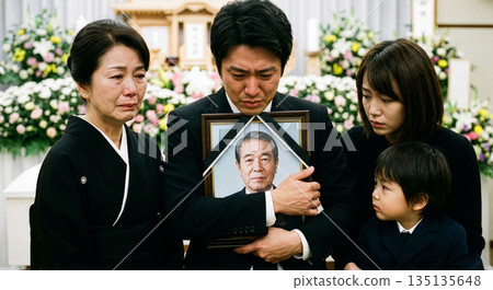 在殯儀館，三代同堂的哀悼者們神情悲痛，他們的兒子手捧著逝者的畫像。 135135648