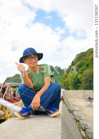 一位老婦人坐在防波堤上(照片由沖繩海濱度假村雅提供) 一位老婦人坐在防波堤上(照片由沖繩海濱度假村雅提供) 135136567