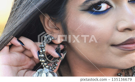 Bangladeshi girl wearing traditional jhumka earring and blue eyeliner makeup 135136679