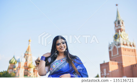 Bangladeshi woman smiling in blue sari in front of Saint Basil's Cathedral, Moscow 135136721