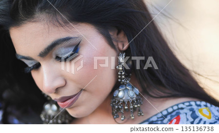 Woman showcasing traditional jewelry and makeup, embodying beauty and cultural identity 135136738