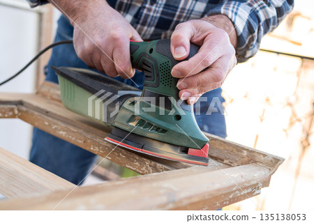Carpenter at work, restoring an old wooden window. Carpentry. 135138053