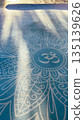 Yoga mat with Om symbol in soft morning light 135139626